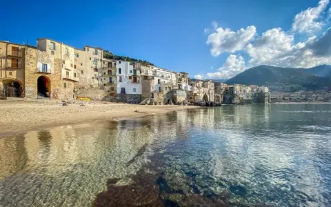 Cefalù, un gioiello da scoprire vicino a Palermo. Case colorate affacciate su una spiaggia dorata e un mare cristallino.