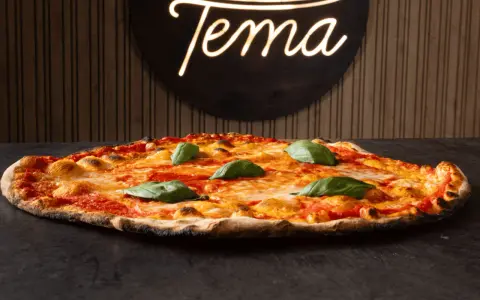 Pizza romana con pomodoro, mozzarella filante e basilico fresco. Ingredienti semplici per un gusto autentico.