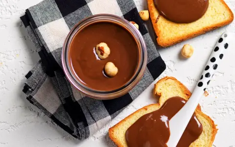 Crema di nocciole fatta in casa, vellutata e golosa, su fette biscottate. Un piacere semplice e genuino.