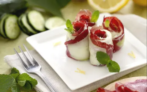 Rotolini di cetrioli con bresaola e formaggio, un'idea fresca per le tue cetrioli ricette. Guarniti con menta e scorza di limone.