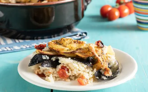 Piatto di riso patate e cozze, ricetta originale pugliese, con pomodorini e patate dorate in forno.