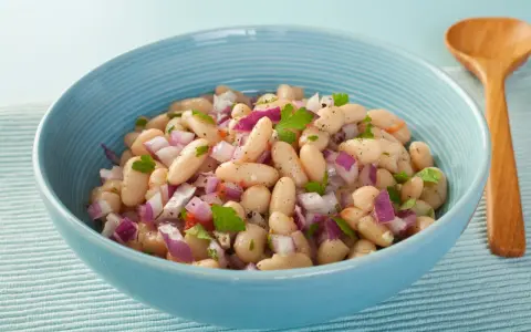 Insalata di fagioli in scatola con cipolla rossa e prezzemolo. Ecco come cucinarli per un contorno veloce e gustoso.