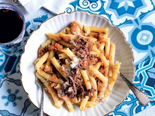 Un piatto invitante di pasta alla genovese, con maccheroni conditi con un ricco ragù di carne e spolverata di parmigiano.