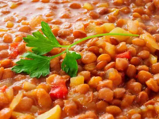Lenticchie stufate con patate e pomodoro, un modo semplice per cucinare le lenticchie secche senza ammollo. Guarnite con prezzemolo fresco.