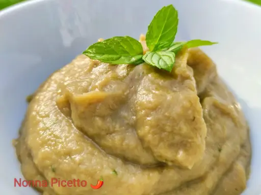 Crema di melanzane per pasta, liscia e vellutata, guarnita con foglie di menta fresca. Un sapore estivo pronto per condire il tuo piatto.