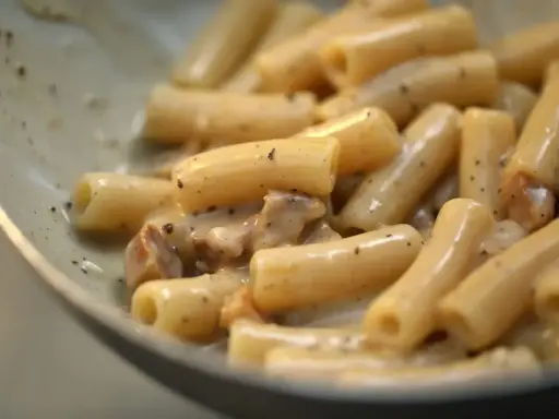 Primo piatto di pasta alla gricia, con rigatoni cremosi e guanciale croccante.