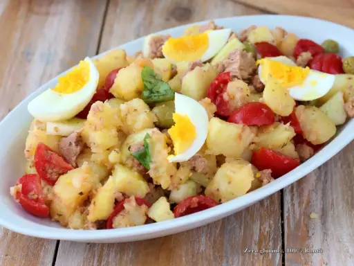 Deliziosa insalata di patate estiva con tonno, uova sode, pomodorini e olive. Un piatto fresco e saporito, perfetto per le giornate calde.