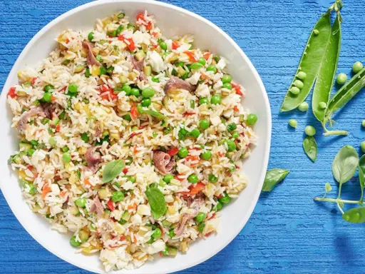 Un'idea fresca per le tue **riso freddo ricette**: un'insalata colorata con piselli, peperoni, acciughe e basilico.