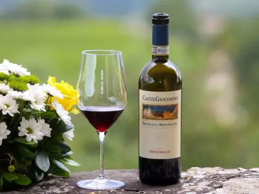 Un bicchiere di Brunello di Montalcino e un mazzo di fiori gialli e bianchi. Perfetti abbinamenti per una cena speciale.