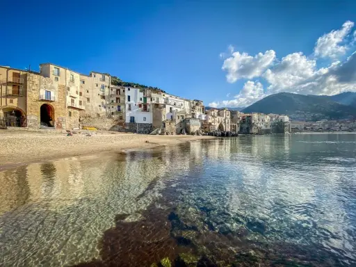 Cefalù, un gioiello da scoprire vicino a Palermo. Case colorate affacciate su una spiaggia dorata e un mare cristallino.