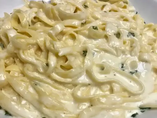 Un piatto cremoso di pasta burro e parmigiano, con erbe aromatiche tritate finemente.