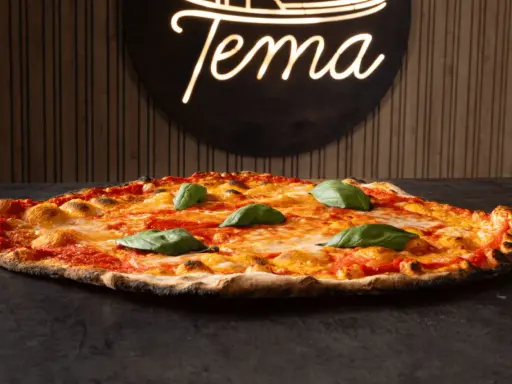 Pizza romana con pomodoro, mozzarella filante e basilico fresco. Ingredienti semplici per un gusto autentico.