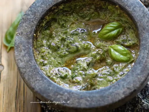 Pesto fresco fatto in casa nel mortaio, con basilico e olio. Una deliziosa alternativa al pesto senza pinoli.