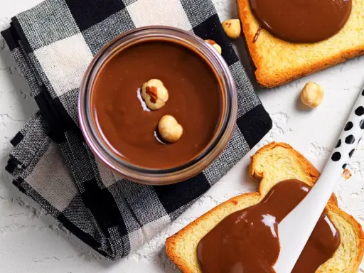 Crema di nocciole fatta in casa, vellutata e golosa, su fette biscottate. Un piacere semplice e genuino.
