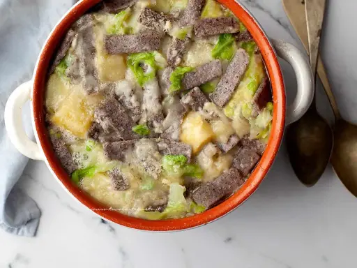 Pizzoccheri ricetta: un piatto fumante di pasta di grano saraceno, patate, verza e formaggio fuso in una casseruola.