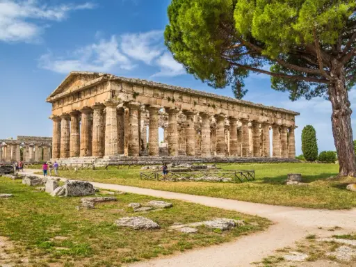 Antichi templi greci a Paestum, dove si trova questo sito archeologico patrimonio UNESCO, con visitatori che passeggiano tra le rovine.