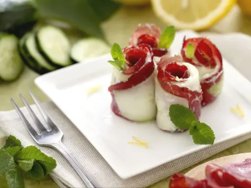 Rotolini di cetrioli con bresaola e formaggio, un'idea fresca per le tue cetrioli ricette. Guarniti con menta e scorza di limone.