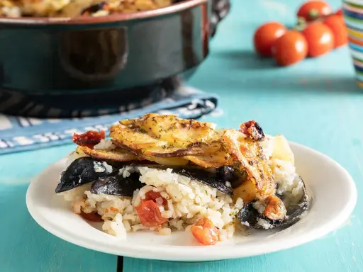 Piatto di riso patate e cozze, ricetta originale pugliese, con pomodorini e patate dorate in forno.