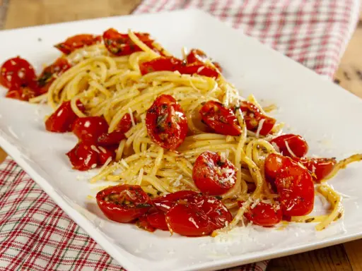Spaghetti con pomodori al forno alla pugliese, un piatto semplice e gustoso, con pomodorini dolci e profumati.