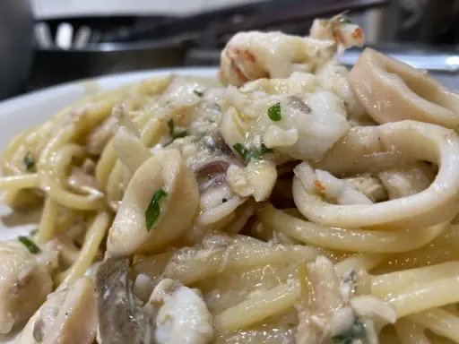 Spaghetti con sugo di pesce, ricchi di calamari e gamberi, un piatto che profuma di mare.