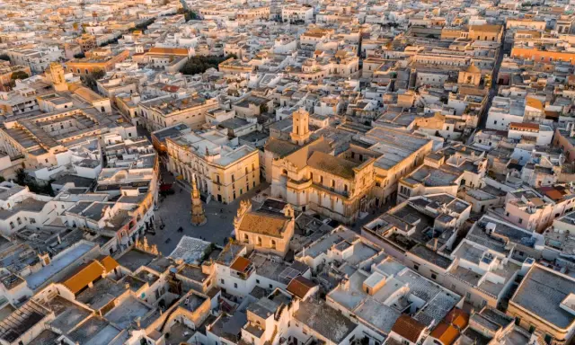 Nardò, dove si trova questo centro storico con chiese barocche e tetti bianchi, illuminato dalla luce dorata del tramonto.