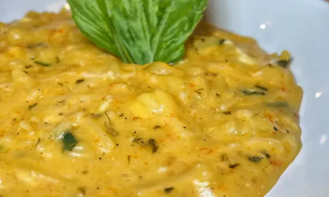 Un cremoso piatto di pasta patate e provola, arricchito da erbe aromatiche e guarnito con una foglia di basilico fresco.