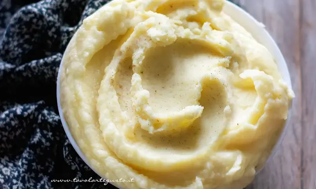 Una ciotola di cremosa crema di patate, soffice e invitante, con un pizzico di pepe nero.