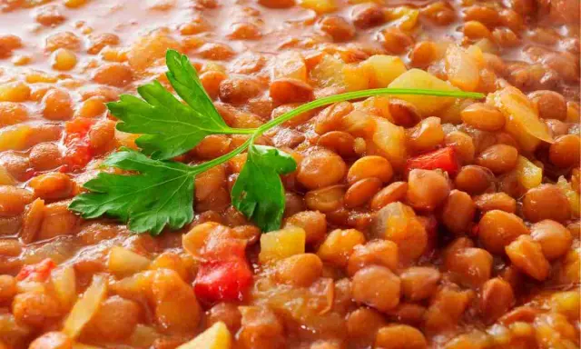 Lenticchie stufate con patate e pomodoro, un modo semplice per cucinare le lenticchie secche senza ammollo. Guarnite con prezzemolo fresco.