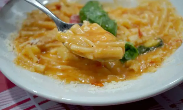Un cucchiaio di pasta e patate alla napoletana, un piatto cremoso e saporito, con basilico fresco e parmigiano.