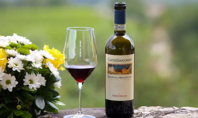 Un bicchiere di Brunello di Montalcino e un mazzo di fiori gialli e bianchi. Perfetti abbinamenti per una cena speciale.