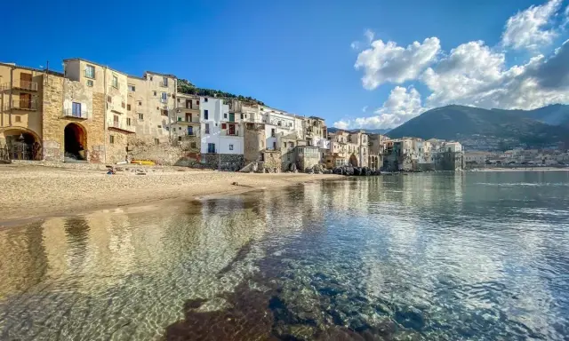 Cefalù, un gioiello da scoprire vicino a Palermo. Case colorate affacciate su una spiaggia dorata e un mare cristallino.
