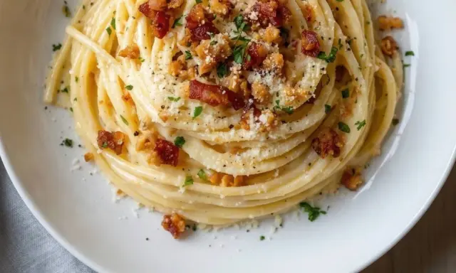 Spaghetti cremosi con guanciale croccante e parmigiano, una deliziosa carbonara vegetariana.