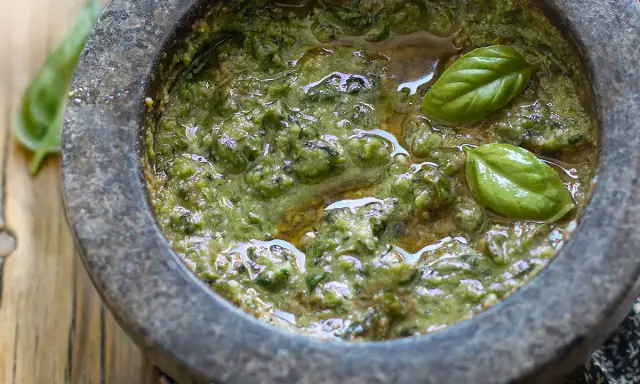 Pesto fresco fatto in casa nel mortaio, con basilico e olio. Una deliziosa alternativa al pesto senza pinoli.