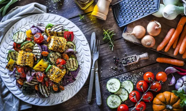Piatto di contorni di verdure sfiziosi e veloci: zucchine, peperoni, cipolle, pomodorini e pannocchie grigliate, condite con erbe aromatiche.