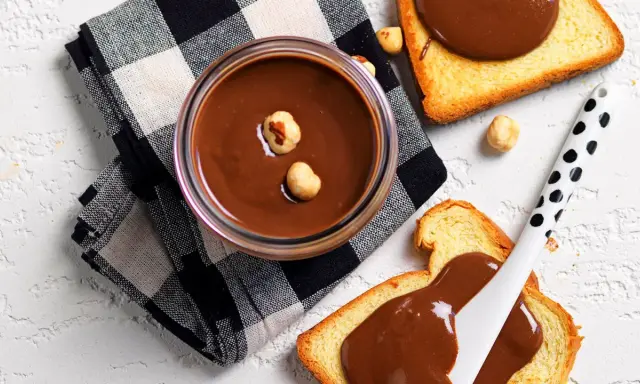 Crema di nocciole fatta in casa, vellutata e golosa, su fette biscottate. Un piacere semplice e genuino.