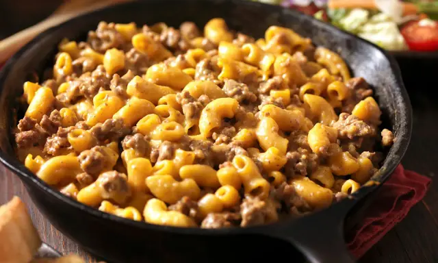 Una padella di pasta panna e salsiccia, cremosa e saporita, pronta per essere gustata.