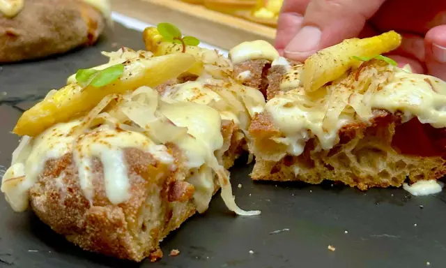 Pizza in padellino con formaggio filante, patate croccanti e un tocco di verde. Una delizia da gustare.