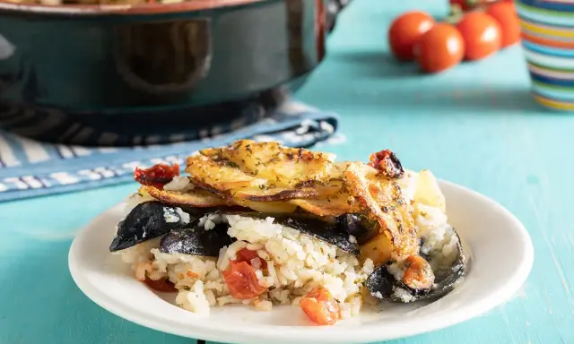 Piatto di riso patate e cozze, ricetta originale pugliese, con pomodorini e patate dorate in forno.