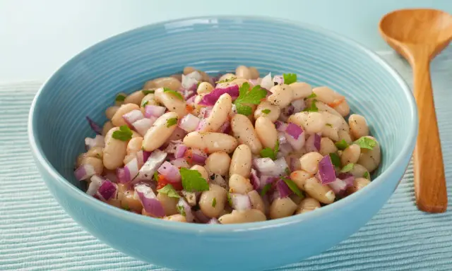 Insalata di fagioli in scatola con cipolla rossa e prezzemolo. Ecco come cucinarli per un contorno veloce e gustoso.