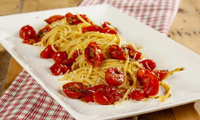 Spaghetti con pomodori al forno alla pugliese, un piatto semplice e gustoso, con pomodorini dolci e profumati.