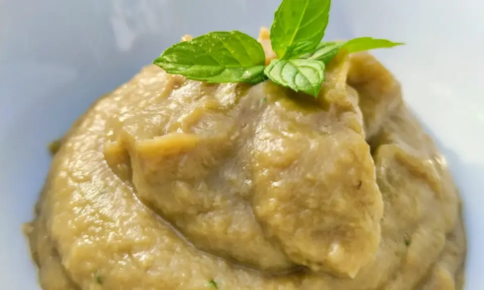 Crema di melanzane per pasta, liscia e vellutata, guarnita con foglie di menta fresca. Un sapore estivo pronto per condire il tuo piatto.