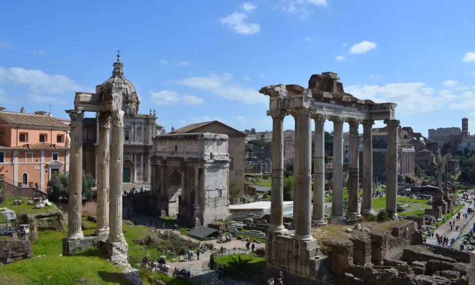 Antiche rovine romane, un arco trionfale e una chiesa con cupola, ideali per scoprire cosa fare a Roma nel weekend.