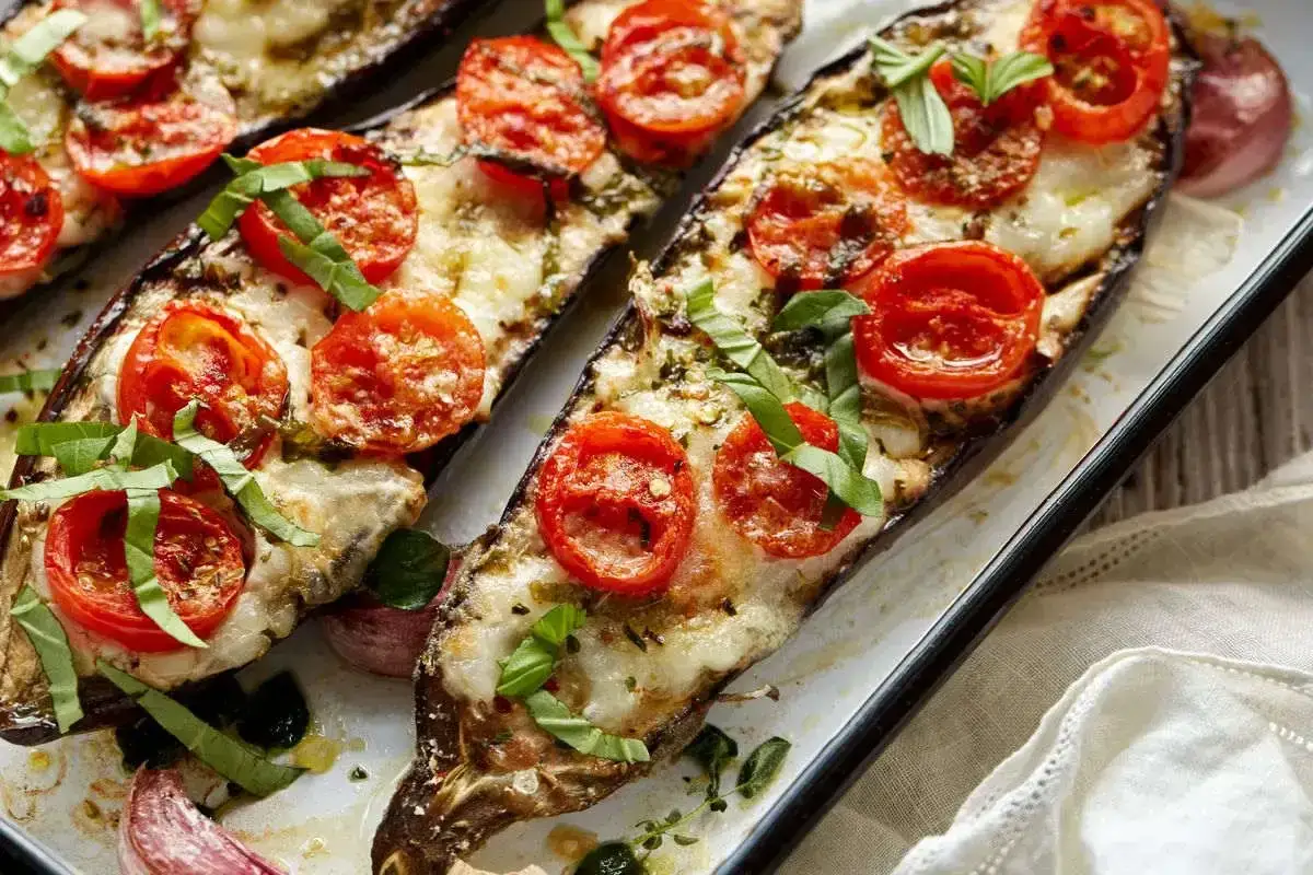 Melanzane ripiene al forno con pomodorini e mozzarella filante. Un'idea gustosa per le tue ricette con melanzane.