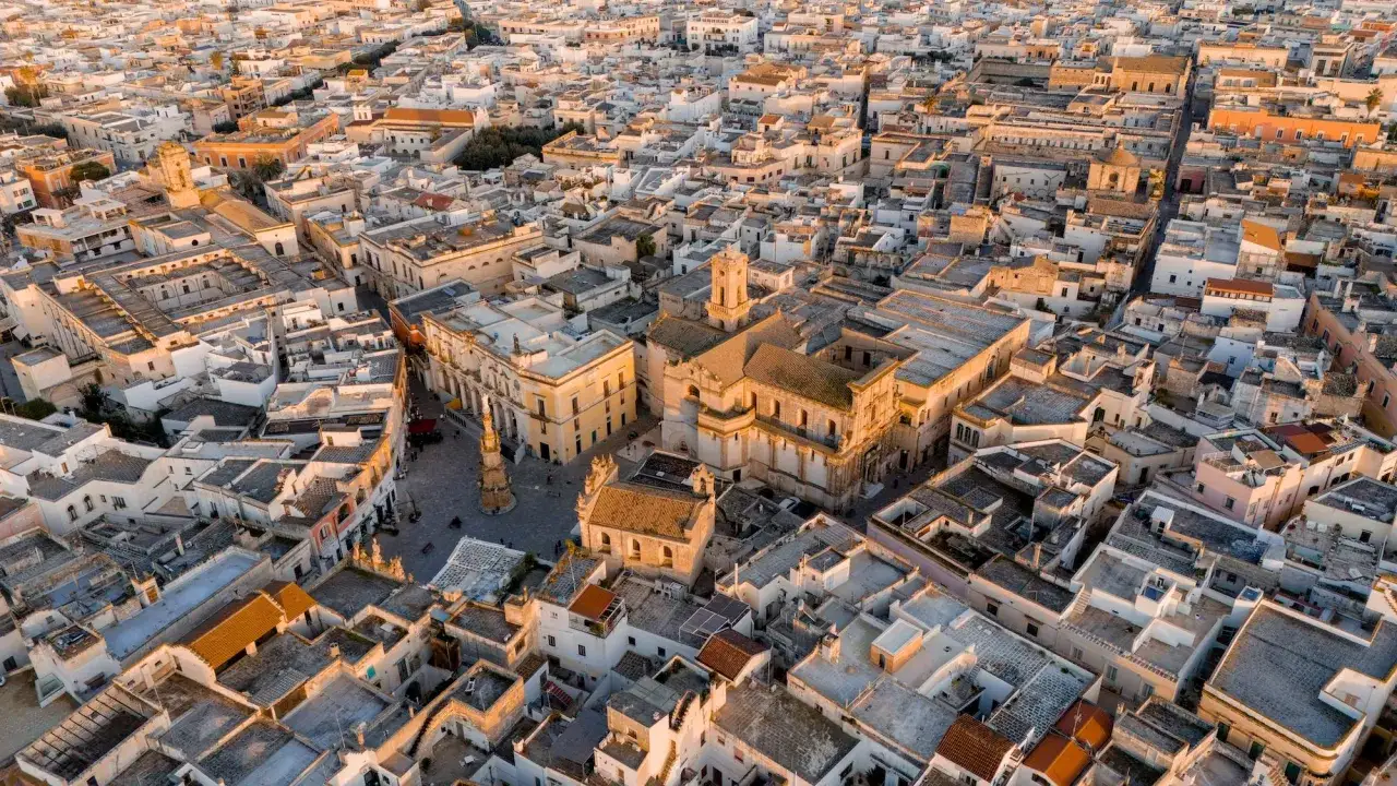 Nard&ograve;, dove si trova questo centro storico pugliese, con i suoi tetti bianchi e gialli illuminati dal sole al tramonto.