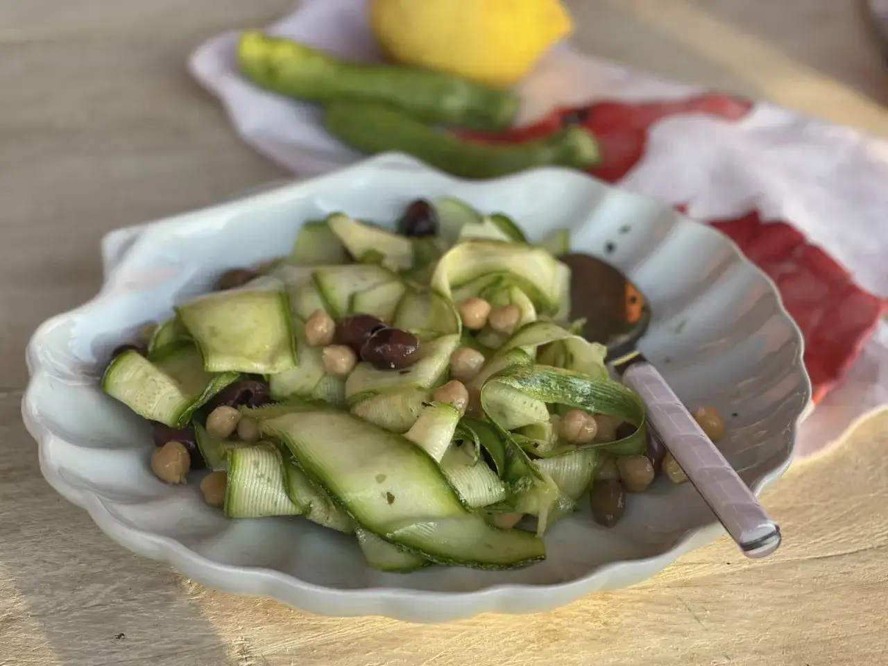Insalata fresca con zucchine a nastro, ceci e olive nere. Un'idea leggera per le tue ricette con farina di ceci.