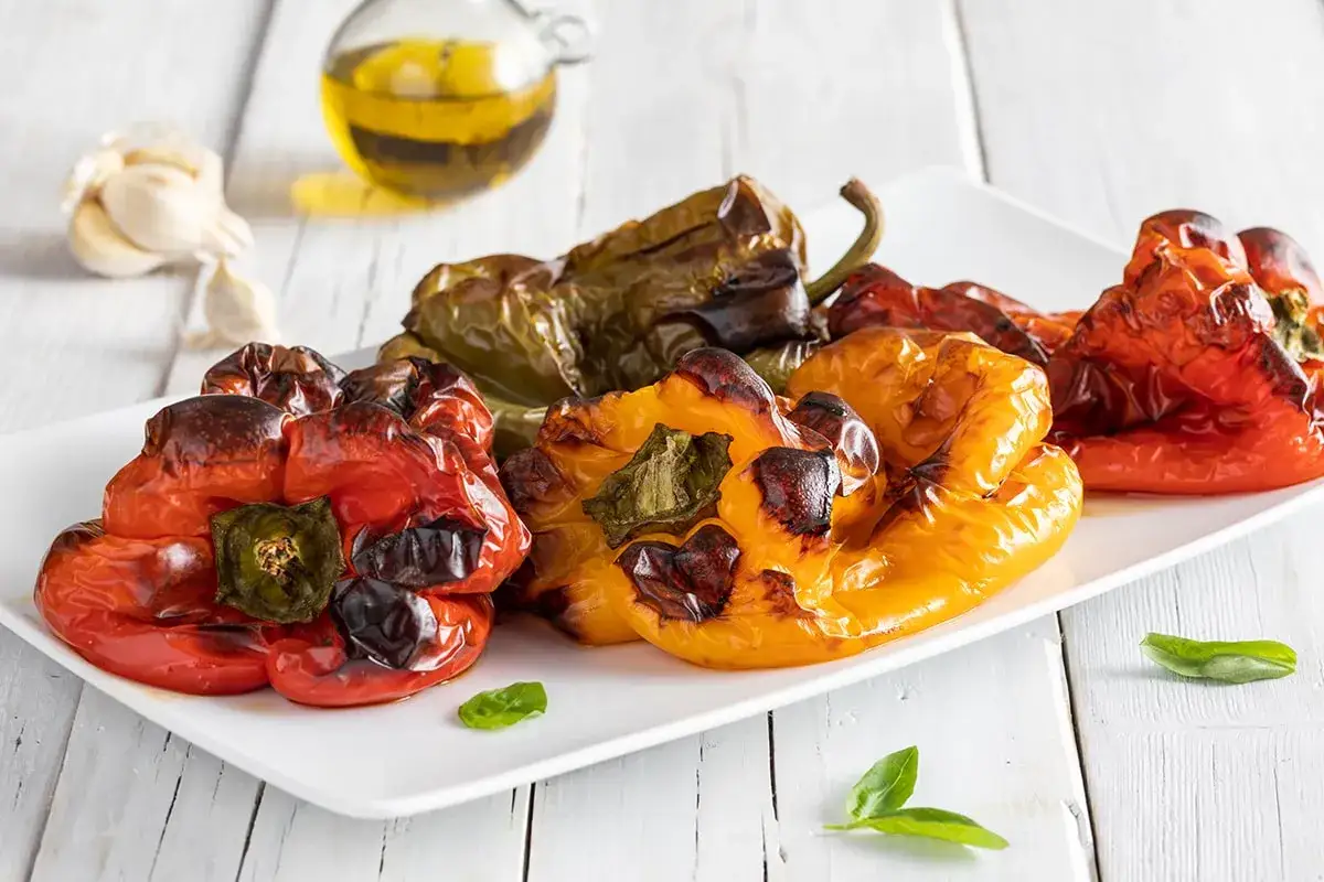 Peperoni arrostiti, un classico delle ricette estive. Rosso, giallo e verde, cotti alla perfezione, pronti per essere gustati.