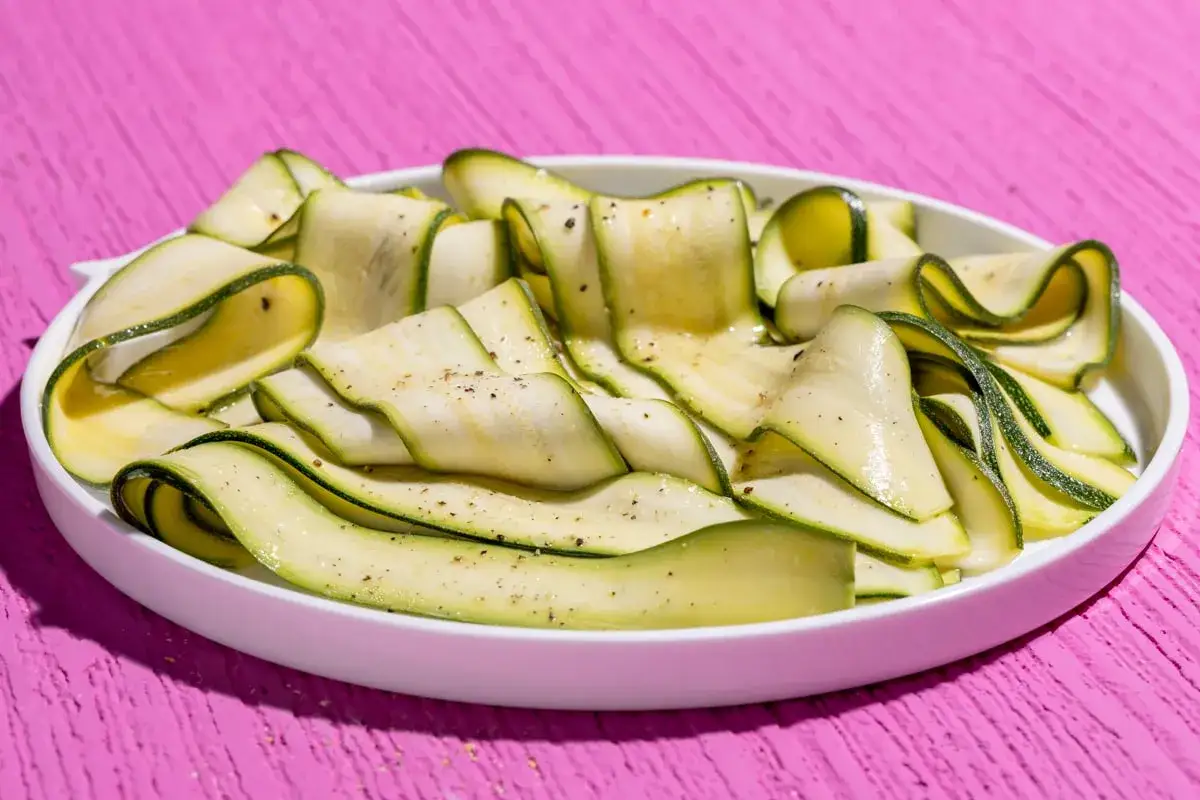 Fettuccine di zucchine condite con olio e pepe, pronte per gustose ricette con zucchine.