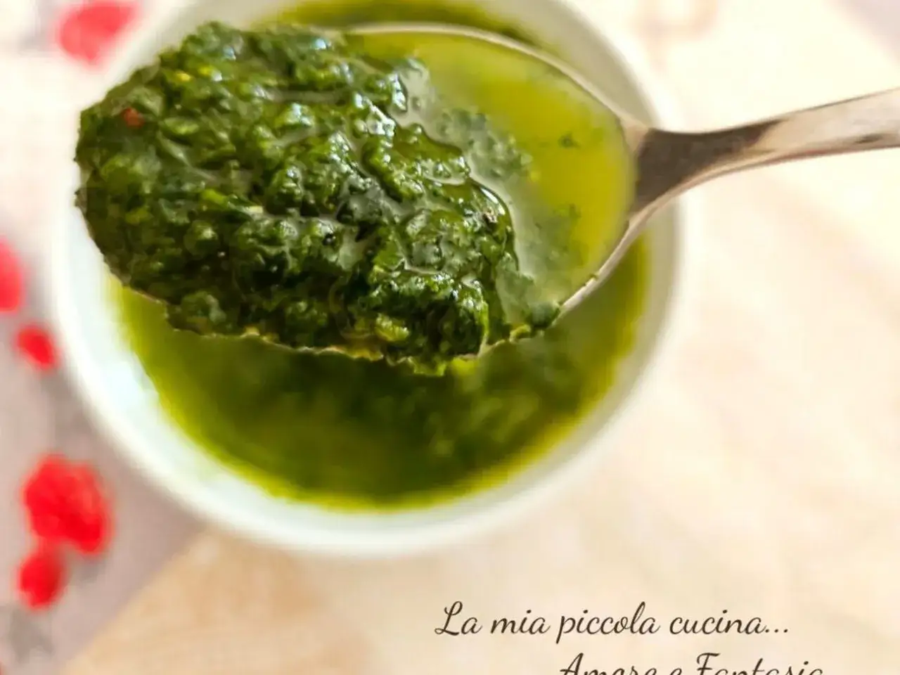 Cucchiaio pieno di pesto senza pinoli, verde brillante, in una ciotola.