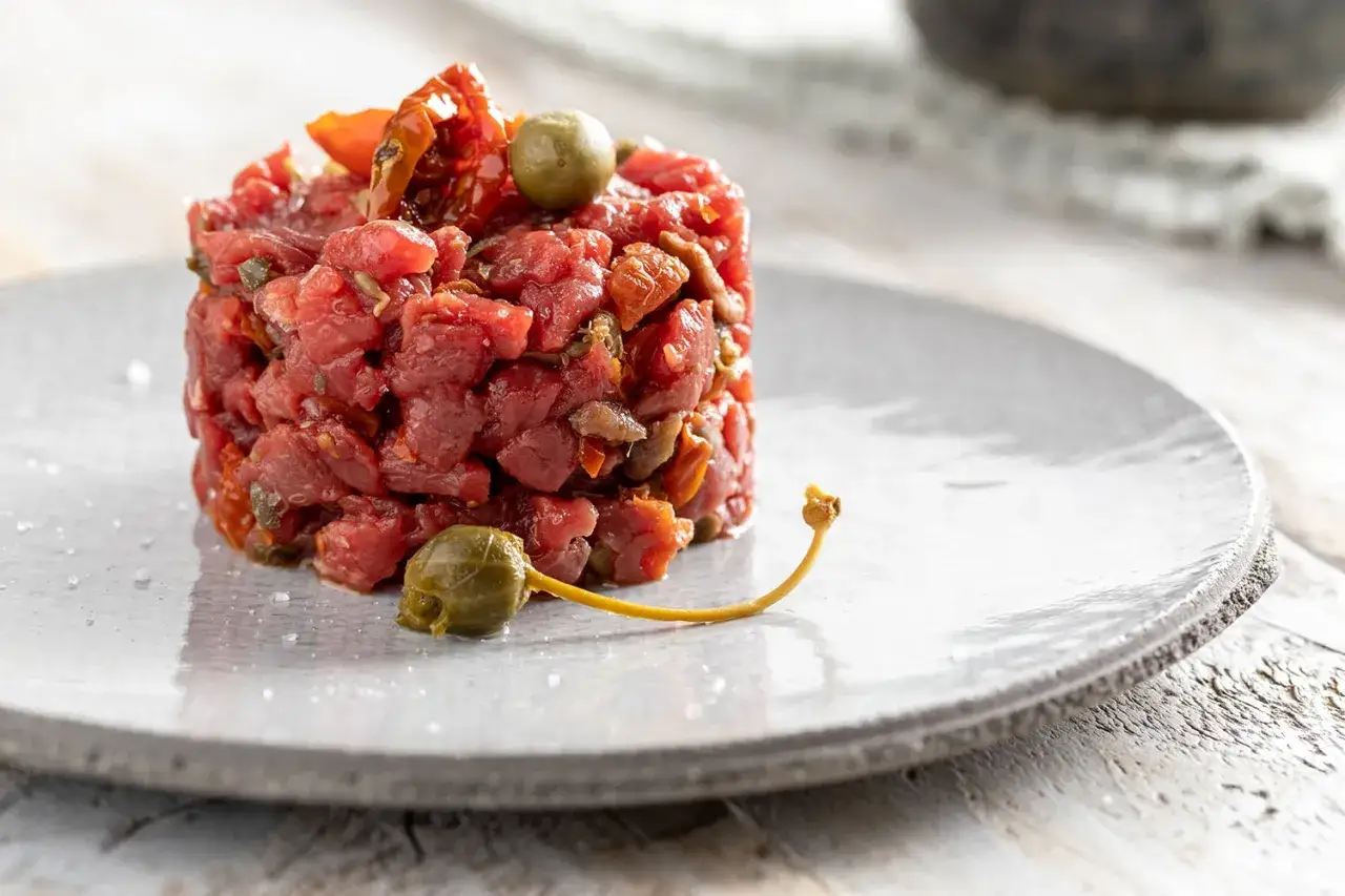 Tartare di manzo con pomodori secchi e capperi. Un'idea su come condirla per un piatto fresco e saporito.