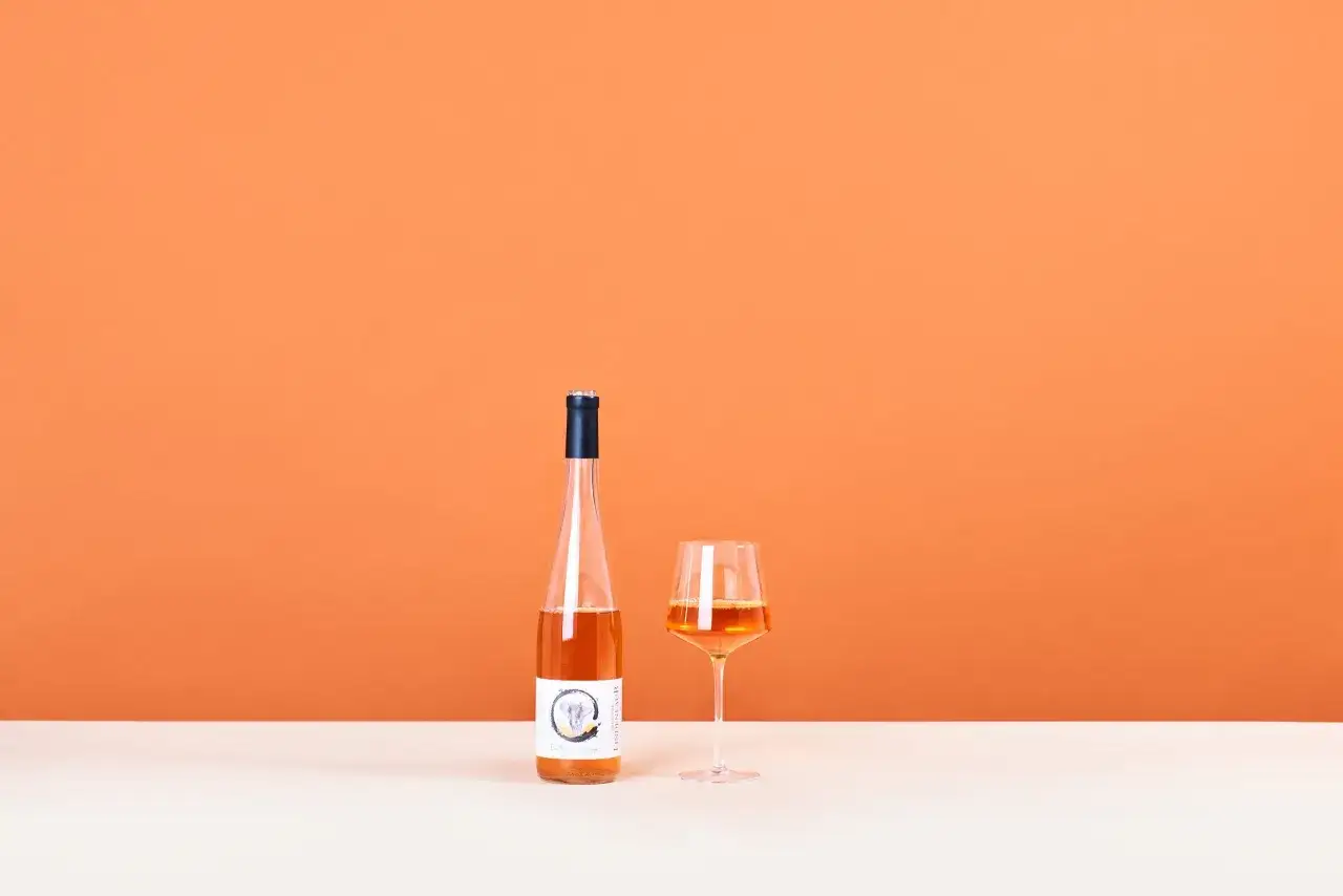 Una bottiglia e un calice di vino arancione, un'introduzione a cosa sono questi vini unici.